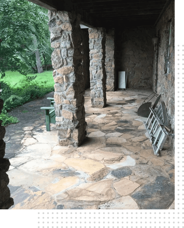 A stone walkway with pillars and benches.